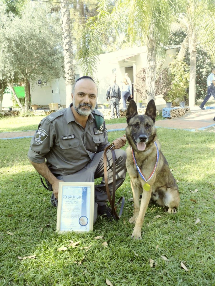 אחד מכלבני המשטרה שזכה במדליה לצד מפעילו | צילום: מג&quot;ב