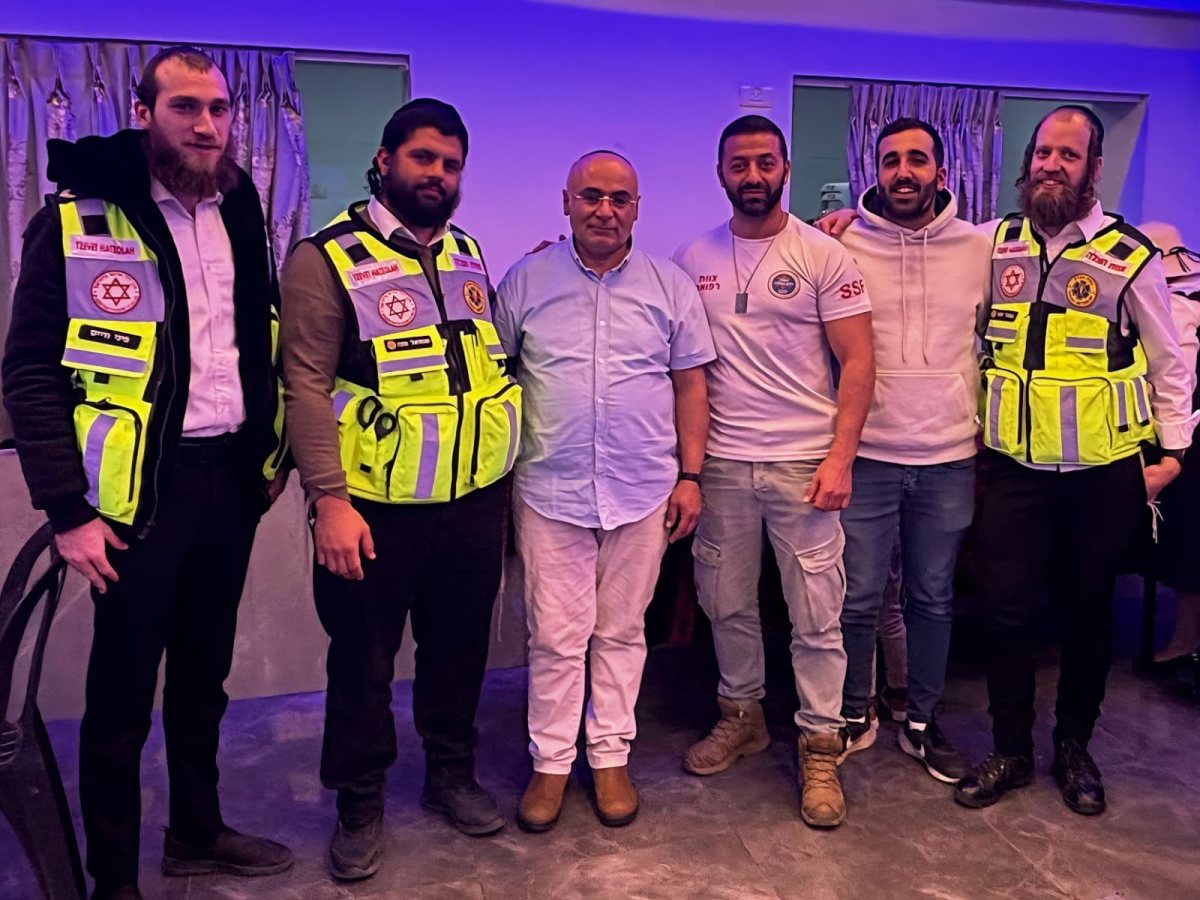 הניצול (במרכז) עם מציליו | צוות הצלה