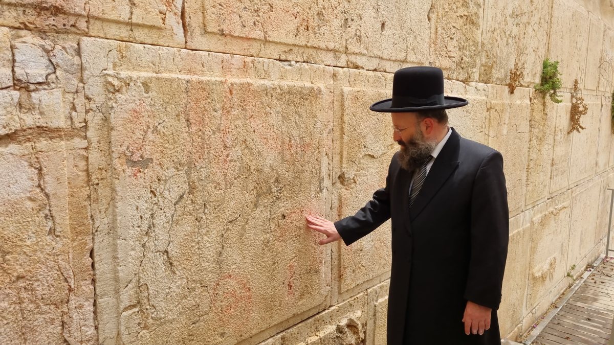 רב הכותל המערבי ליד האבן שנוקתה. הקרן למורשת הכותל