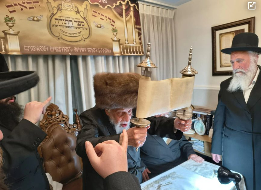 האדמו"ר מקופיטשניץ מגביה את ספר התורה העתיק | צילום: בית קופיטשניץ