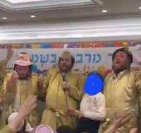 יענקי שישא (במרכז) משמח את לב היתומים. נטע שפר