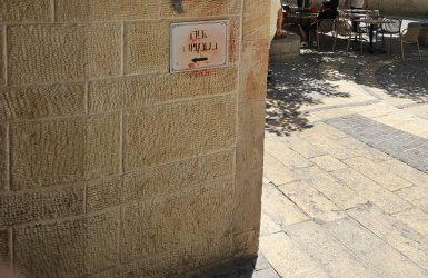 שלט, שהושחת על ידי מפגינים, עם שמו של בית הקפה | צילום: Pinhas stern ויקיפדיה
