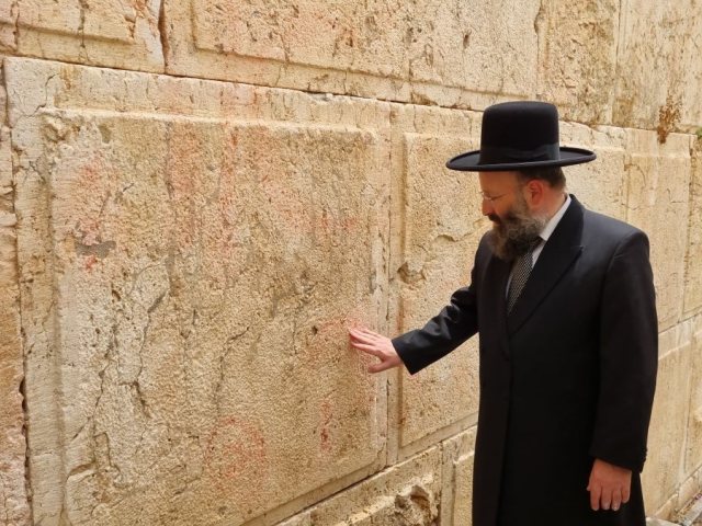 רב הכותל המערבי ליד האבן שנוקתה. הקרן למורשת הכותל