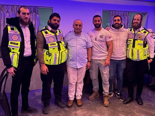 הניצול (במרכז) עם מציליו | צוות הצלה